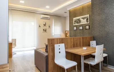 a restaurant with a wooden table and white chairs at Apartment Barcelona in Belgrade