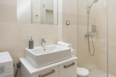 a white bathroom with a sink and a shower at Apartment Barcelona in Belgrade