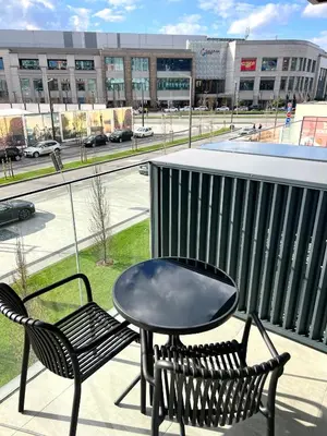a table and two chairs on a balcony with a view of a street at Belgrade Waterfront- Libera in Belgrade