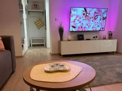 a living room with a table and a tv at Apartment Fiore in Smederevo