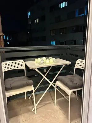 a table and chairs on a balcony with a view of a building at Apartment Fiore in Smederevo
