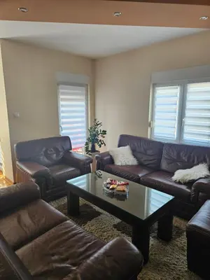 a living room with couches and a coffee table at Apartman Cvijetinovic in Ruma