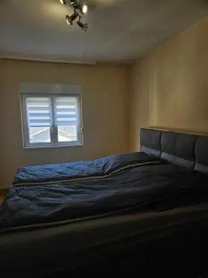 a bedroom with a bed and a window at Apartman Cvijetinovic in Ruma