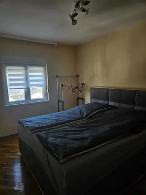 a bedroom with a bed with a blue blanket at Apartman Cvijetinovic in Ruma
