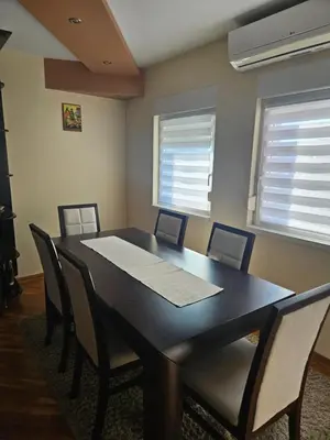 a dining room with a black table and chairs at Apartman Cvijetinovic in Ruma