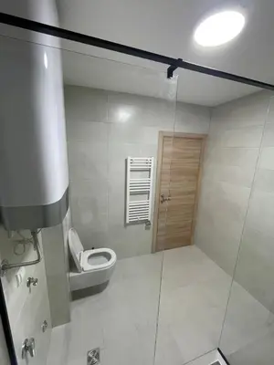 a bathroom with a toilet and a glass shower stall at Deluxe apartment Magnolia 2 in Belgrade