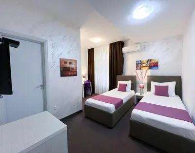 a hotel room with two beds with purple sheets at Centar Forever in Belgrade