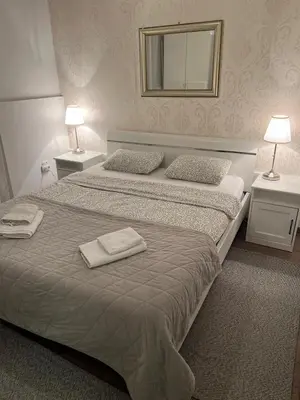 a bedroom with two beds and two lamps and a mirror at City Apartments Ana in Belgrade