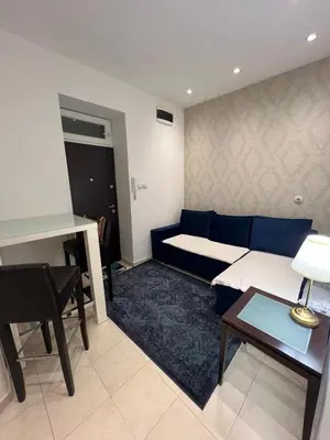 a living room with a blue couch and a table at City Apartments Ana in Belgrade