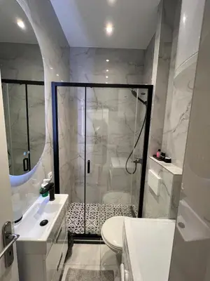 a white bathroom with a shower and a toilet at City Apartments Ana in Belgrade