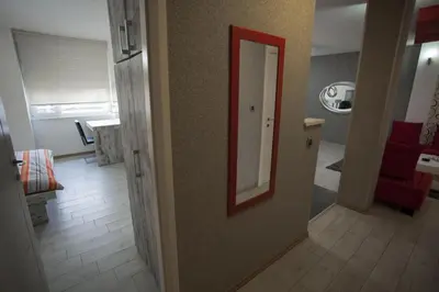 a hallway with a mirror and a living room at Apartment Red in Belgrade