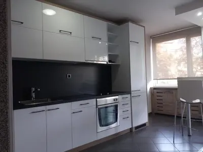 a kitchen with white cabinets and a sink and a window at Apartment Red in Belgrade