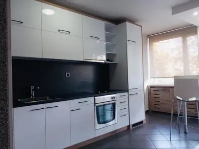 a kitchen with white cabinets and a sink and a window at Apartment Red in Belgrade