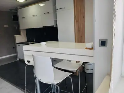 a kitchen with white counters and white stools at Apartment Red in Belgrade