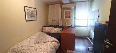 a bedroom with a bed and a dresser and a window at Blossom in Belgrade