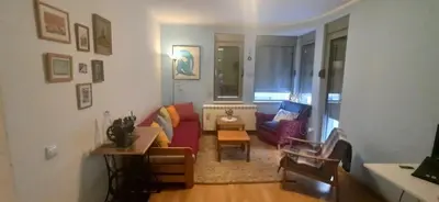 a living room with a red couch and a chair at Blossom in Belgrade