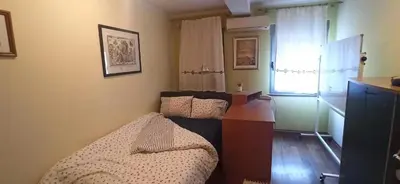 a bedroom with a bed and a dresser and a window at Blossom in Belgrade