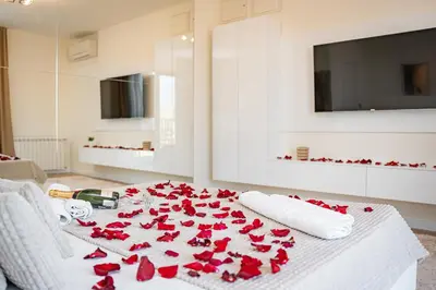 a white bed with red roses on it at Sinfonia Lux 1205 in Sajmište