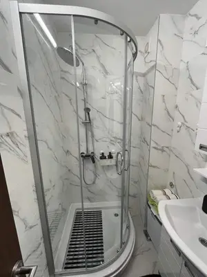 a white bathroom with a shower and a sink at ANDREA in Mali Mokri Lug