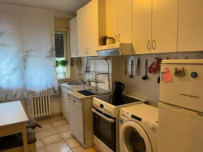 a kitchen with yellow cabinets and a washer and dryer at İstanbul apartment 2 in Belgrade