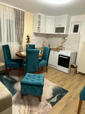 a kitchen with a table and chairs in a room at Apartman Krejović in Arandjelovac