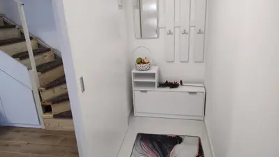 a white kitchen with a counter and a staircase at Apartman Krejović in Arandjelovac