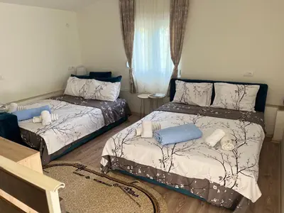 a bedroom with two beds and a table at Apartman Krejović in Arandjelovac