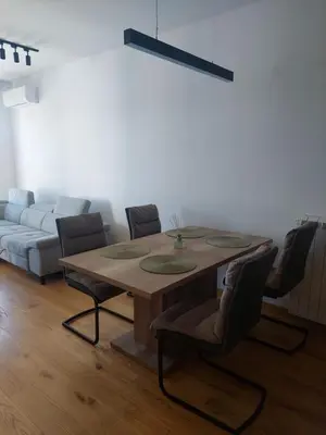 a dining room table with chairs and a couch at Jana apartment in Belgrade
