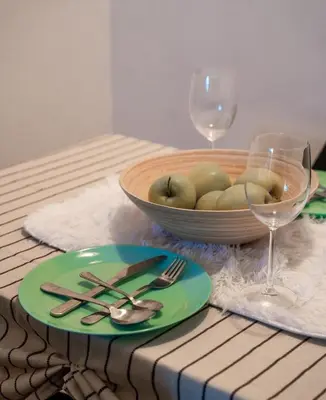 a table with a plate of food and a bowl of fruit at Tea Apartman Obrenovac in Obrenovac