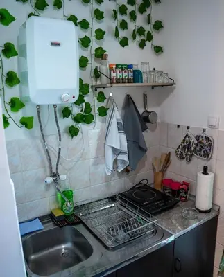 a kitchen counter with a sink and a stove at Tea Apartman Obrenovac in Obrenovac