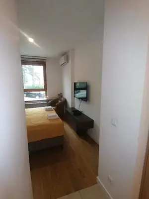a small room with a bed and a television at Skyline Studio Belgrade in Belgrade