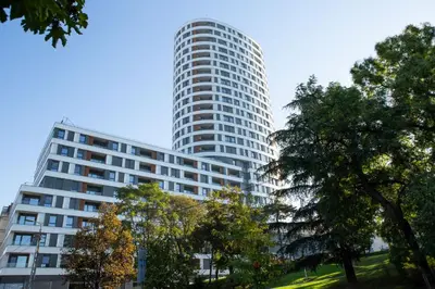 a tall white building with trees in front of it at Skyline Studio Belgrade in Belgrade