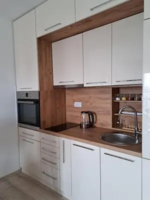 a kitchen with white cabinets and a sink at Apartman Bross in Ruma