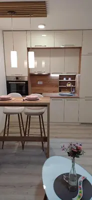 a kitchen with a table and two stools and a table at Apartman Bross in Ruma