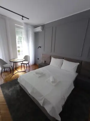 a bedroom with a large white bed and a table at KaLuMa2 in Belgrade
