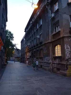 a group of people walking down a street next to a building at KaLuMa2 in Belgrade