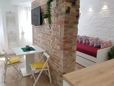a living room with a brick wall and a couch at VeryBell in Belgrade
