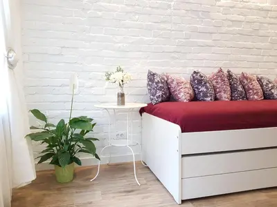 a bedroom with a bed with a white brick wall at VeryBell in Belgrade