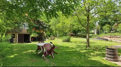 a table and chairs sitting in a grass yard at Log cabin in Belgrade