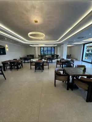a dining room with tables and chairs and a chandelier at Nobel West Hotel in Belgrade