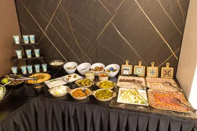 a buffet of food on a black table at Nobel West Hotel in Belgrade