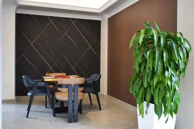 a dining room with a table and chairs and a plant at Nobel West Hotel in Belgrade