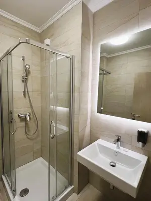 a bathroom with a shower and a sink and a glass shower stall at Nobel West Hotel in Belgrade