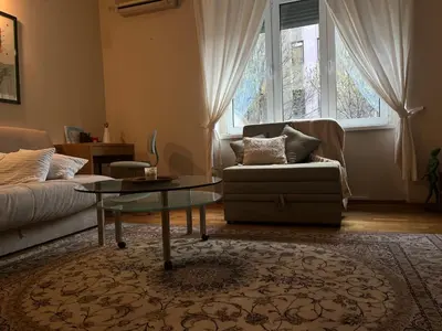 a living room with a couch and a glass table at DeeM-LUX in Belgrade