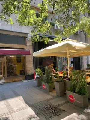 a table with an umbrella in front of a store at DeeM-LUX in Belgrade