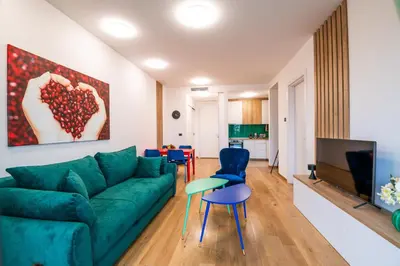 a living room with a green couch and chairs at City Center - Sunrise Apartment with Parking in Belgrade