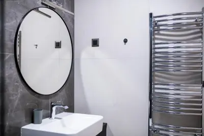 a bathroom with a sink and a mirror at City Center - Sunrise Apartment with Parking in Belgrade