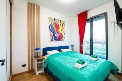a bedroom with a bed with two towels on it at City Center - Sunrise Apartment with Parking in Belgrade