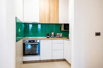 a kitchen with white cabinets and a stove at City Center - Sunrise Apartment with Parking in Belgrade