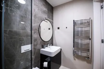 a bathroom with a sink and a mirror at City Center - Sunrise Apartment with Parking in Belgrade